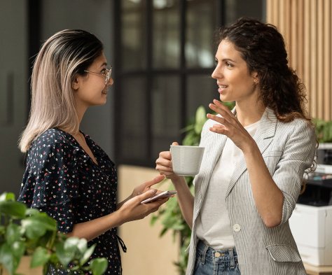 Twee vrouwen overleggen onder het genot van een kopje koffie
