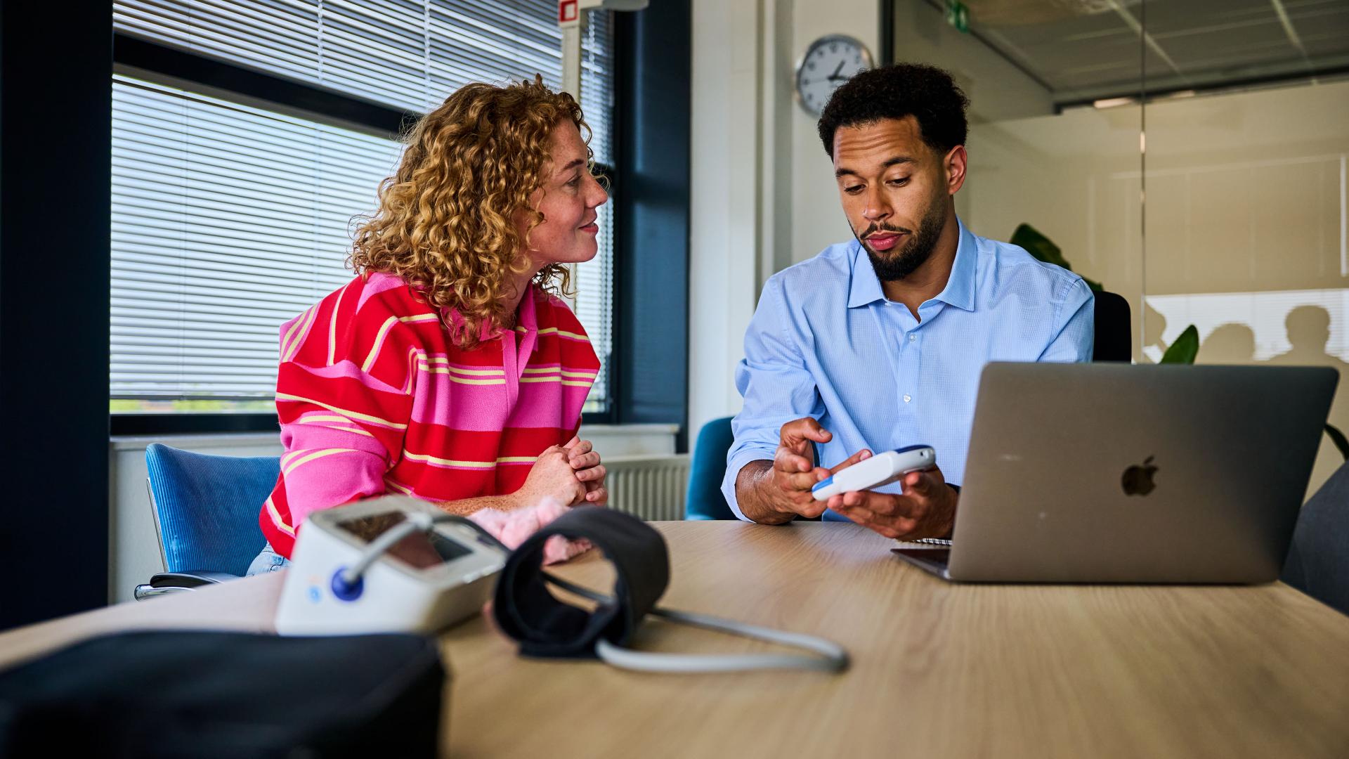 Vitaliteit- en gezondheidsdeskundige in gesprek met medewerker.