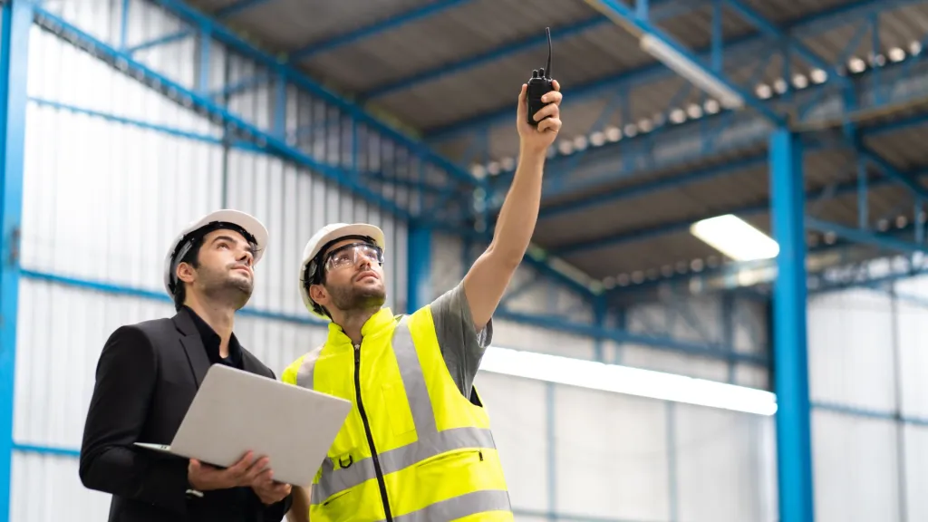 man wijst naar boven in fabriek