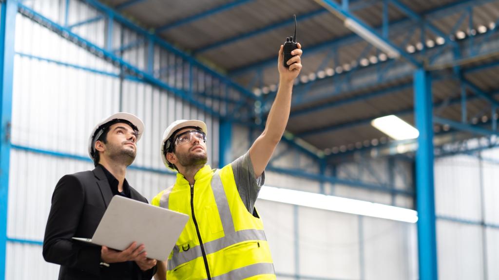 man wijst naar boven in fabriek