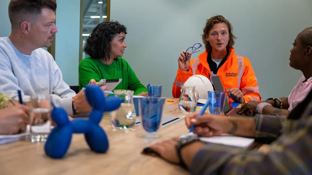 Veiligheidskundige in overleg met medewerkers.