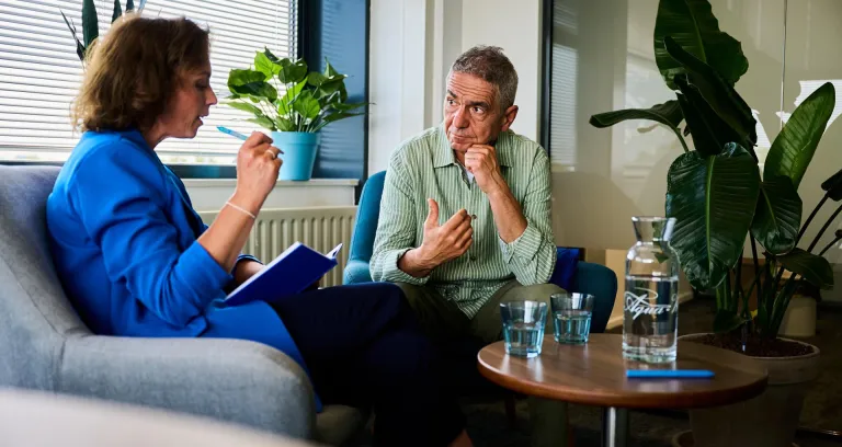 Bedrijfsmaatschappelijk werker in gesprek met medewerker.