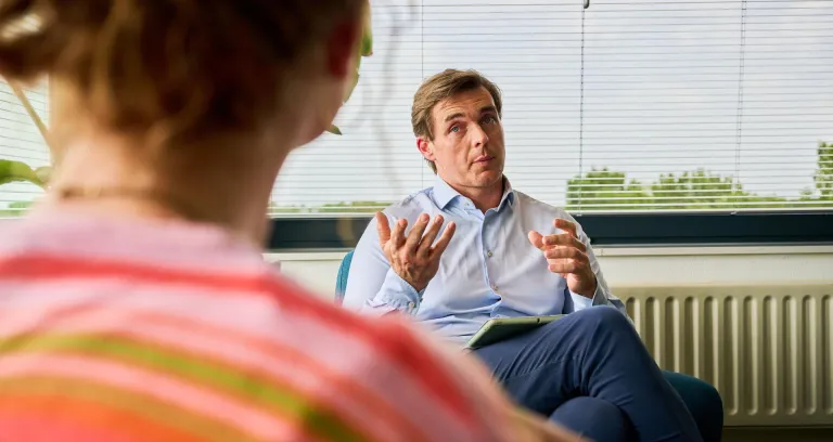 Medewerker in gesprek met vertrouwenspersoon. 