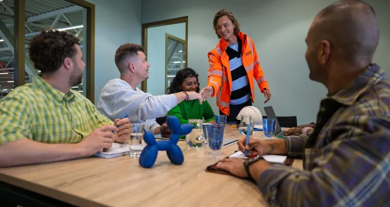 Veiligheidskundige in overleg met medewerkers.