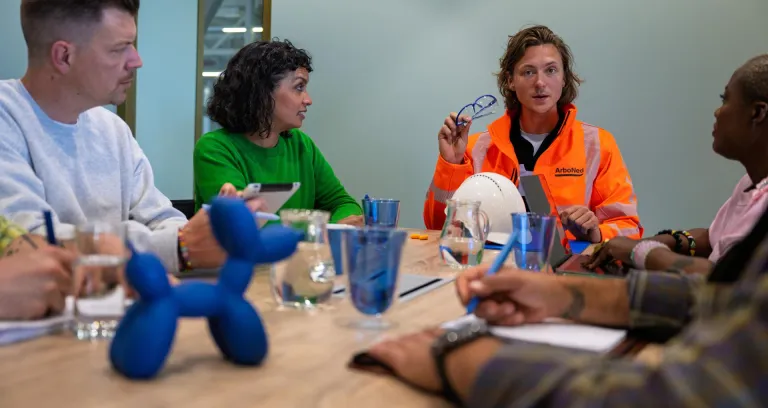 Veiligheidskundige in overleg met medewerkers.