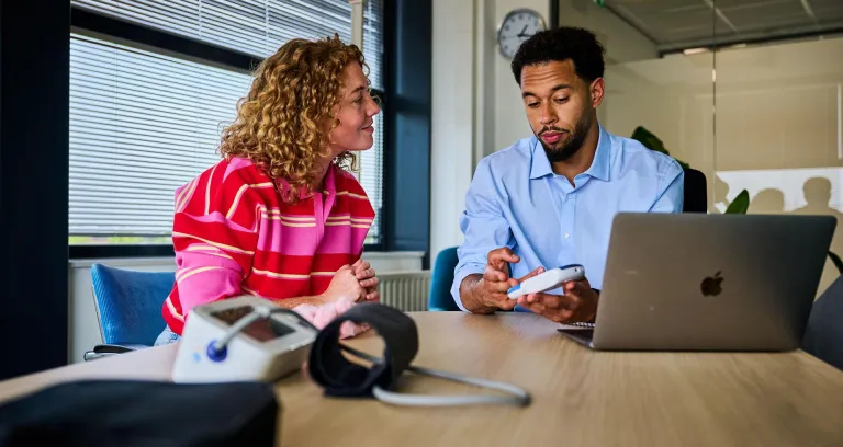 Vitaliteit- en gezondheidsdeskundige in gesprek met medewerker.